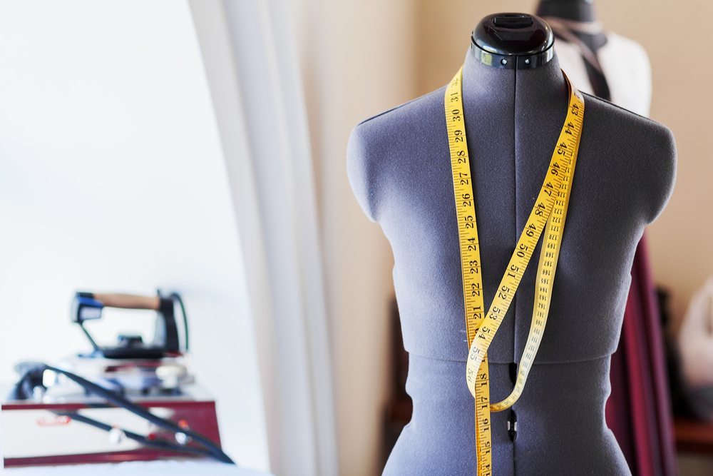 Black dummy with measuring tape in tailors studio